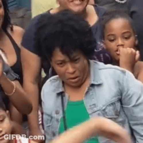 Woman In Denim Jacket Sitting In Crowd GIF