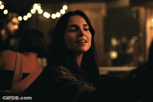 Woman In Denim Jacket Sitting In Dark Room GIF
