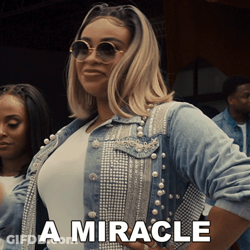Woman In Denim Jacket With Pearls Saying Miracle GIF