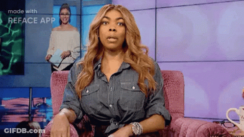 Woman In Denim Shirt Sitting In Pink Chair Making Face GIF