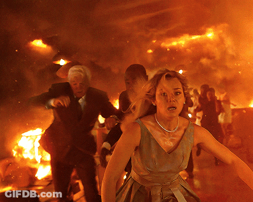 Woman In Dress Running From Burning Building GIF