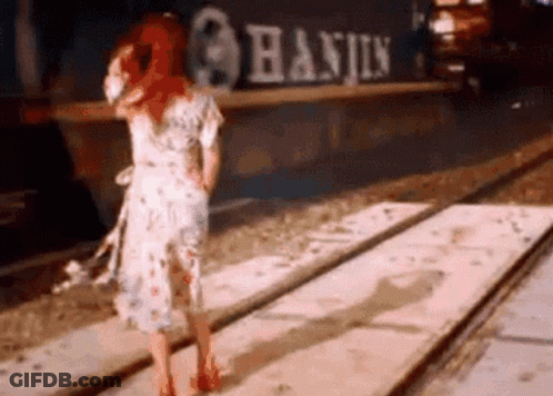 Woman In Dress Standing On Train Track In Front Of Train GIF
