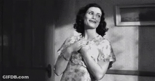 Woman In Dress Standing With Hands On Chest GIF