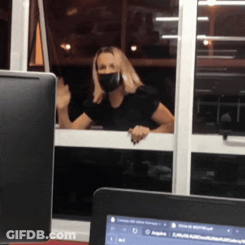 Woman In Face Mask Looking Out Window GIF