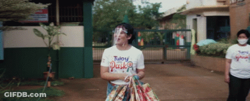 Woman In Face Shield And White Tuloy Pasko Shirt GIF