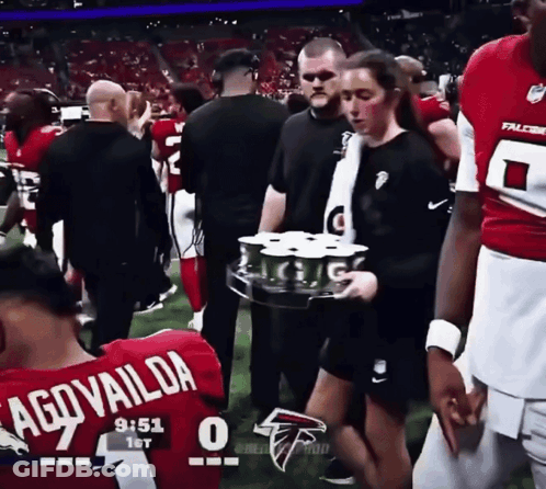 Woman In Falcons Jersey Carrying Tray Of Drinks GIF