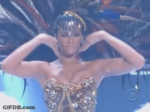 Woman In Feathered Headdress And Gold Top GIF