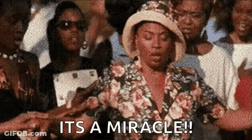 Woman In Floral Dress And Hat Says It's A Miracle GIF