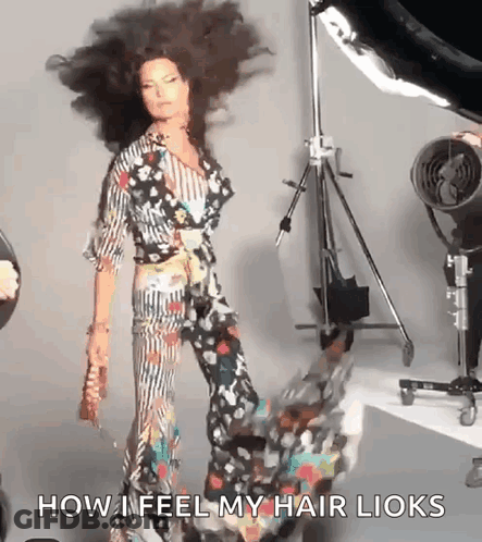 Woman In Floral Dress Hair Blowing By Tripod GIF
