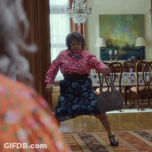 Woman In Floral Dress Holding Purse GIF