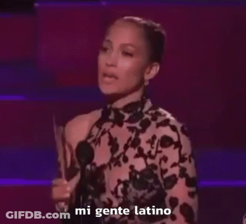 Woman In Floral Dress Holding Trophy Saying Mi Gente Latino GIF
