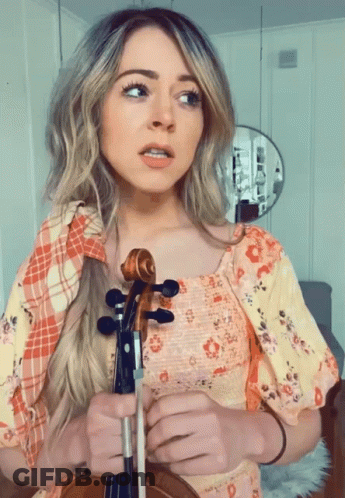 Woman In Floral Dress Holding Violin GIF