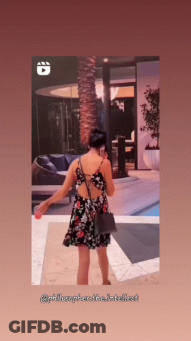 Woman In Floral Dress In Front Of Building GIF