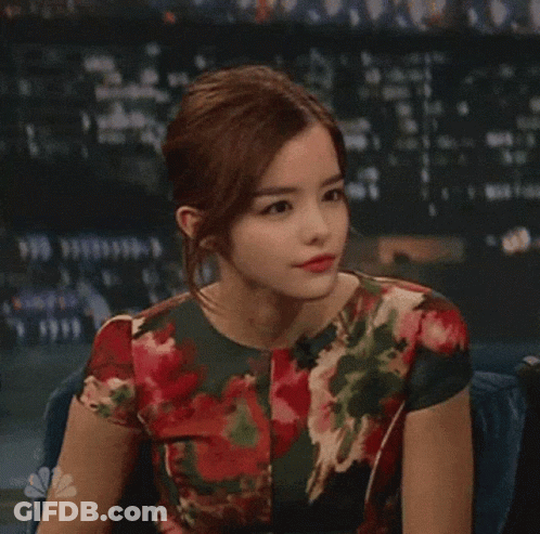 Woman In Floral Dress Sitting At Microphone GIF