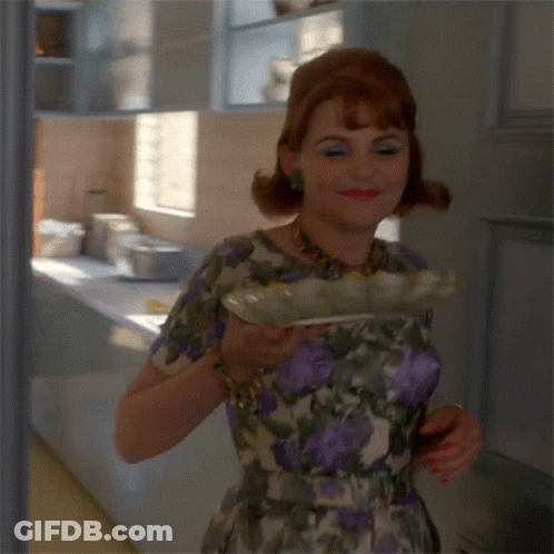 Woman In Floral Dress Smiling Holding Plate GIF