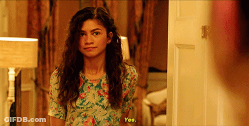 Woman In Floral Dress Standing In Front Of Door GIF