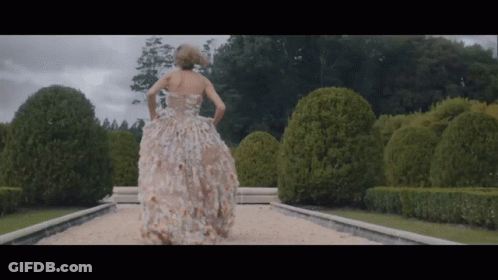 Woman In Floral Dress Walking Down Path GIF