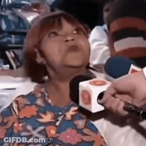 Woman In Floral Shirt Interviewed By Man With Microphone GIF