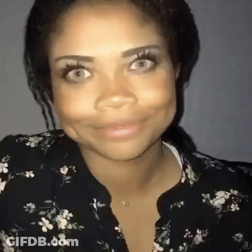 Woman In Floral Shirt Smiling And Making Face GIF