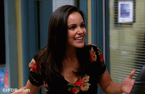 Woman In Floral Shirt Smiling And Waving Hand GIF