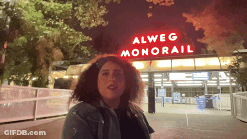 Woman In Front Of Alweg Monorail Sign GIF