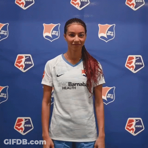Woman In Front Of Blue Wall Saying NW Barnaba Health GIF