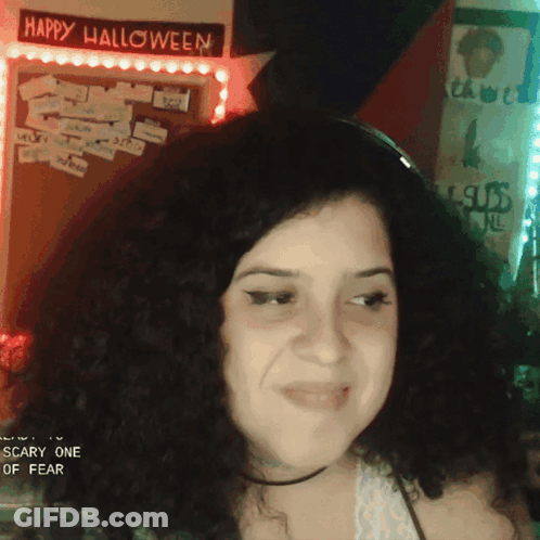 Woman In Front Of Happy Halloween Sign GIF