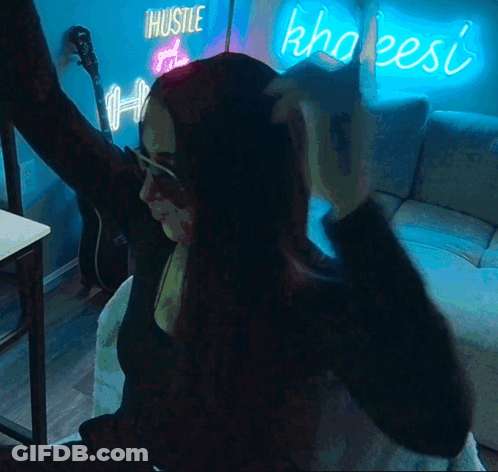 Woman In Front Of Hustle And Khaleesi Neon Sign GIF