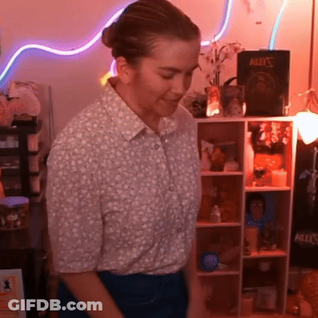 Woman In Front Of Shelf With Book Bullet's GIF