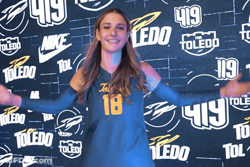 Woman In Front Of Wall With Toledo Logos GIF