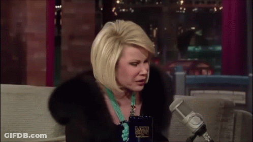 Woman In Fur Coat Sitting At Microphone With Late Show Cup GIF