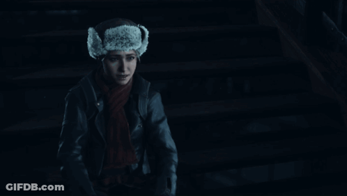 Woman In Fur Hat And Scarf Smiling In Dark GIF