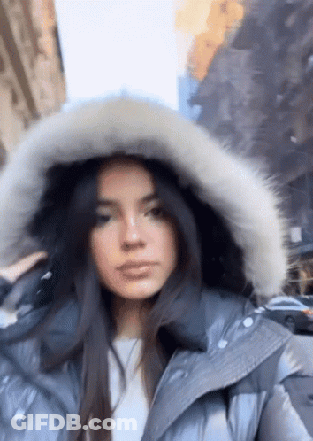 Woman In Fur Hooded Jacket Walking Down Street GIF