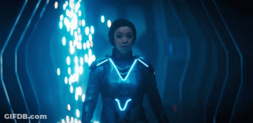 Woman In Futuristic Suit In Dark Room With Blue Light GIF