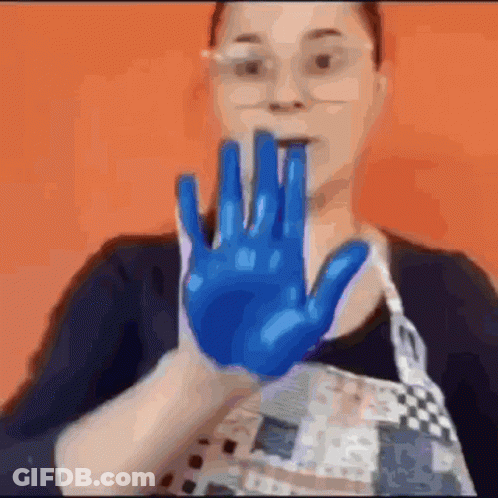 Woman In Glasses And Apron Holding Up Blue Hand GIF