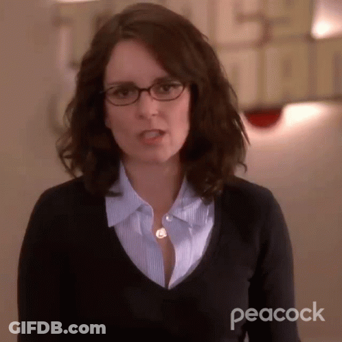 Woman In Glasses And Black Sweater With Peacock Logo GIF
