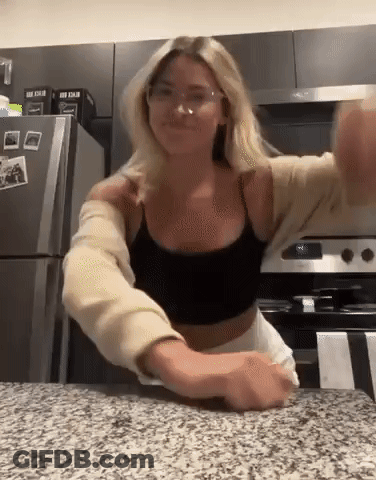 Woman In Glasses And Black Tank Top Standing In Kitchen GIF