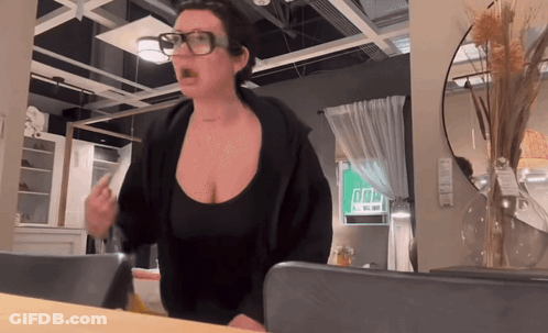Woman In Glasses And Black Top Standing In Room GIF