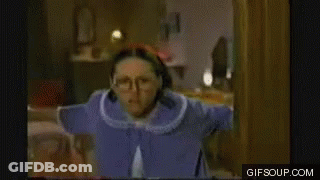 Woman In Glasses And Blue Robe Standing In Room GIF