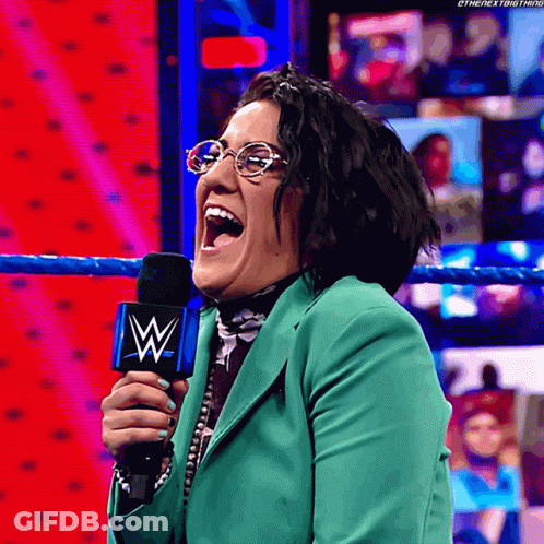 Woman In Glasses And Green Jacket Holding Microphone With W GIF