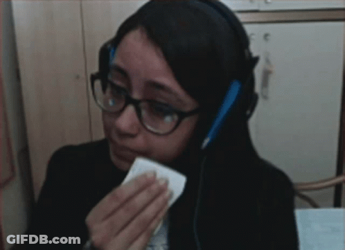 Woman In Glasses And Headphones Wiping Eyes With Tissue GIF