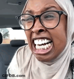 Woman In Glasses And Hijab Making Funny Face While Driving GIF