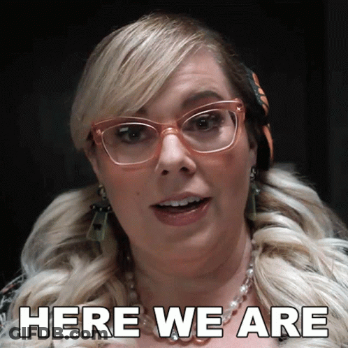 Woman In Glasses And Necklace Says Here We Are GIF