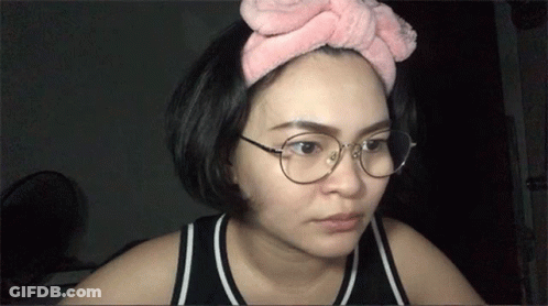 Woman In Glasses And Pink Headband Looking At Camera GIF