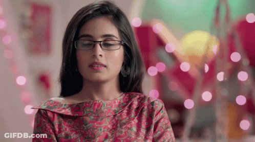 Woman In Glasses And Pink Shirt Looking Down GIF