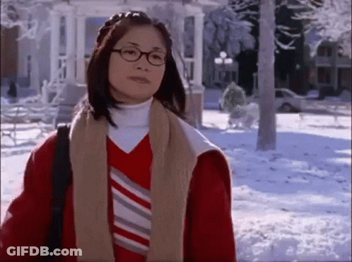Woman In Glasses And Red Jacket Standing In Snow GIF