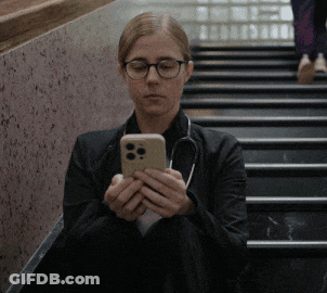 Woman In Glasses And Stethoscope Sitting On Stairs Looking At Phone GIF