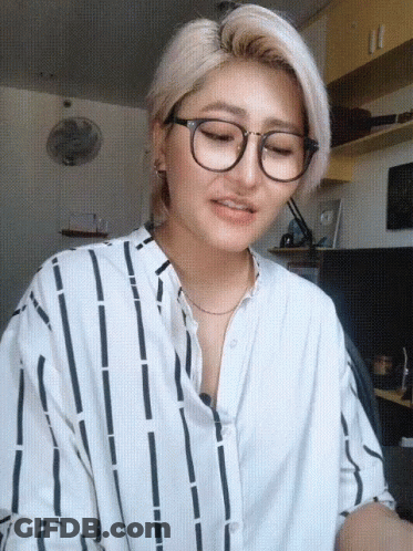 Woman In Glasses And Striped Shirt Looking Down GIF