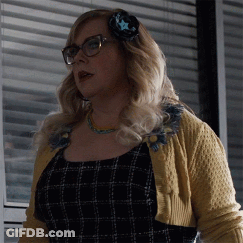 Woman In Glasses And Yellow Sweater In Front Of Window GIF
