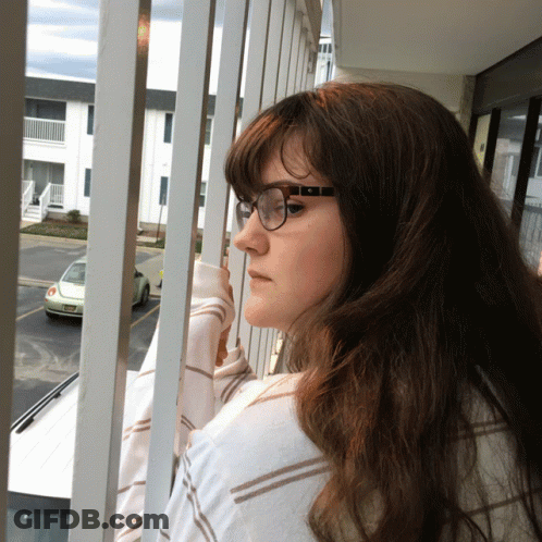 Woman In Glasses Looking Out Window GIF